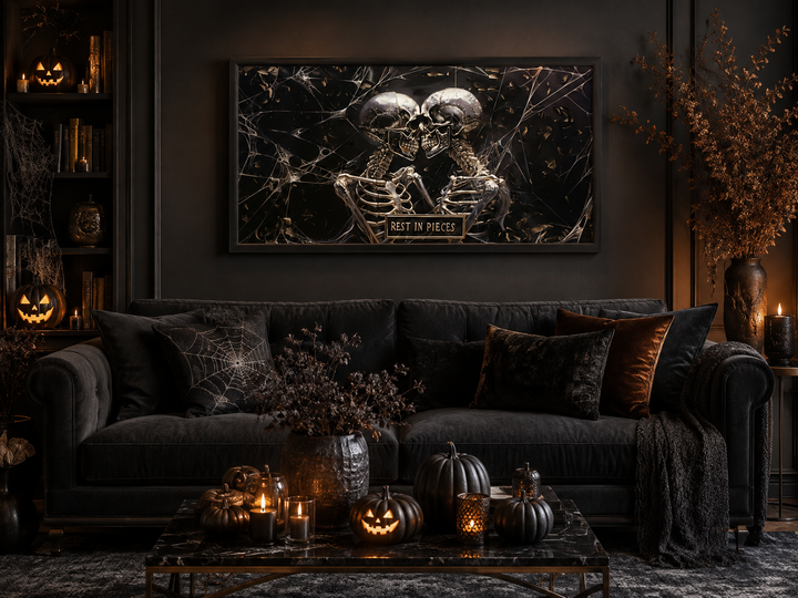 Framed gothic wall art of two skeletons with a "Rest In Pieces" plaque in a dark living room.