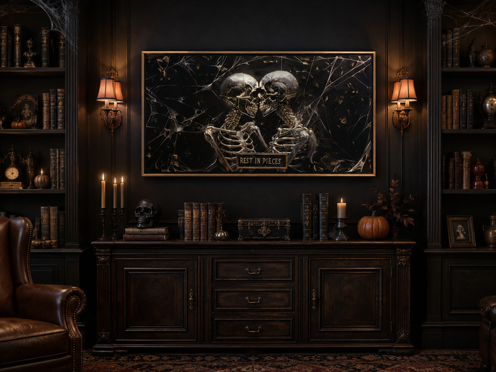 Framed gothic wall art of two skeletons with a "Rest In Pieces" plaque in a dark, moody library.