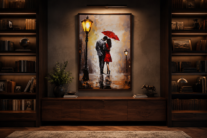 Framed canvas wall art of a couple under a red umbrella in the rain, hung above a wooden sideboard.