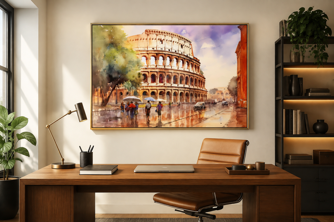 Framed watercolor canvas art of the Colosseum in Rome above a wooden desk in a home office.