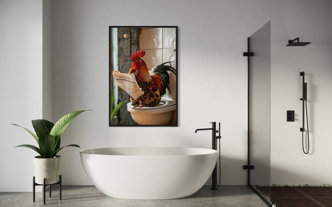 Framed canvas art of a rooster reading a newspaper on a toilet, hanging in a modern bathroom.