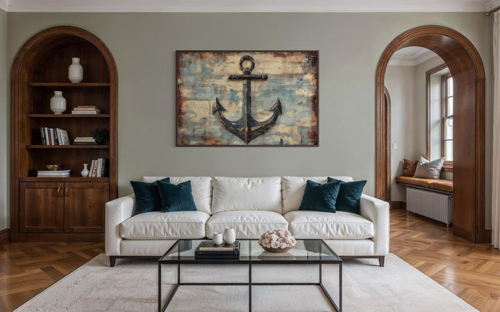 Rustic anchor canvas wall art with a weathered maritime design centered above a white sofa.