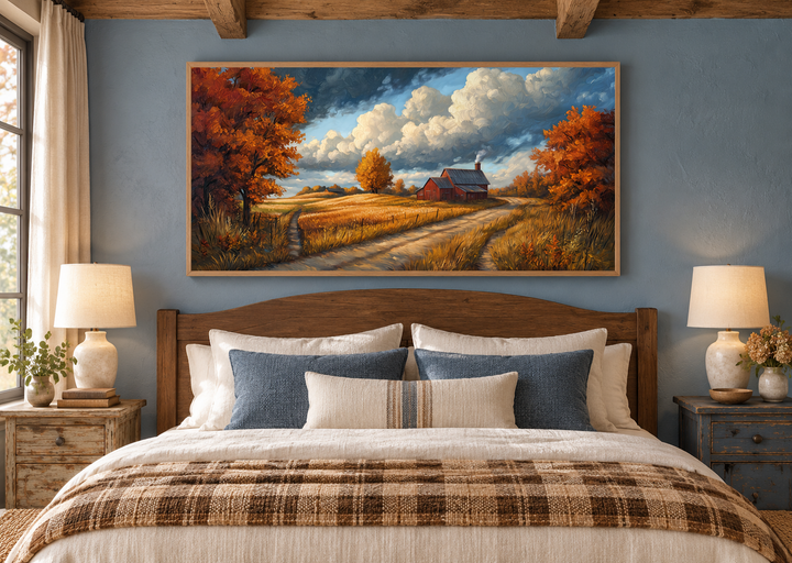 Rustic autumn barn landscape wall art in a wooden frame above a bed in a farmhouse bedroom.