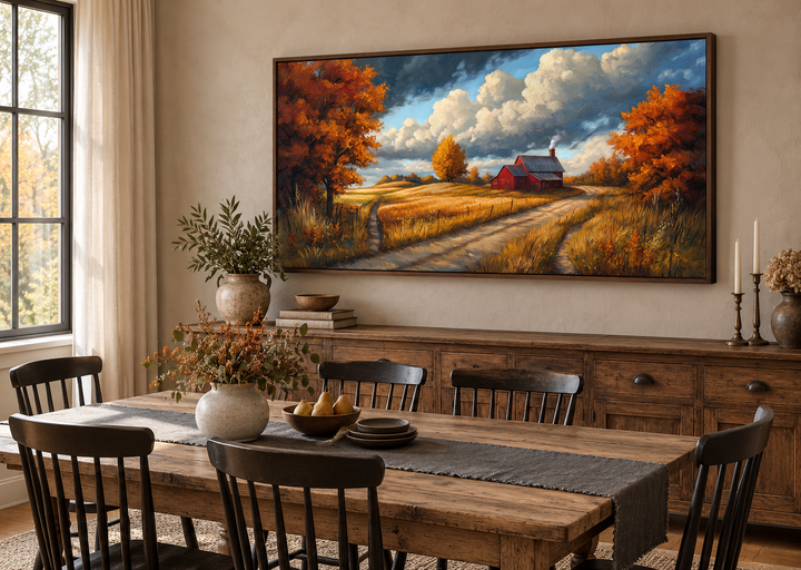Rustic autumn barn landscape painting in a dark wood frame above a farmhouse dining table.