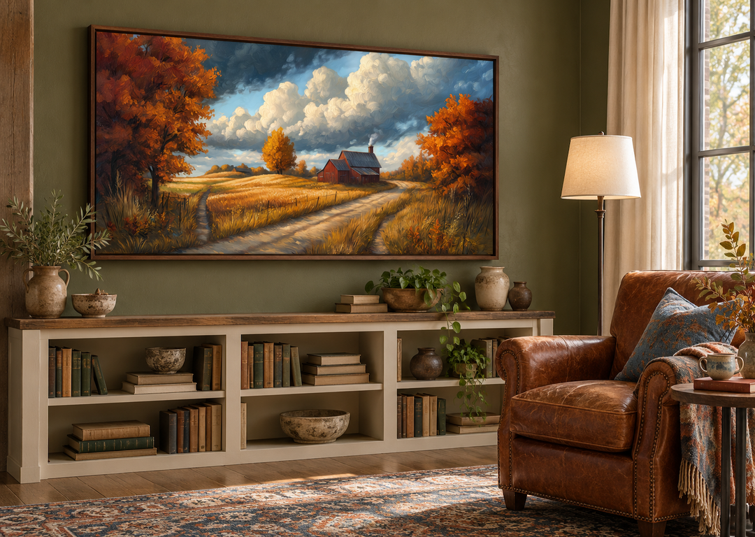 Rustic autumn barn landscape wall art in a walnut frame above a bookshelf in a cozy reading room.
