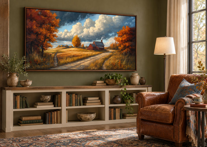 Rustic autumn barn landscape wall art in a walnut frame above a bookshelf in a cozy reading room.