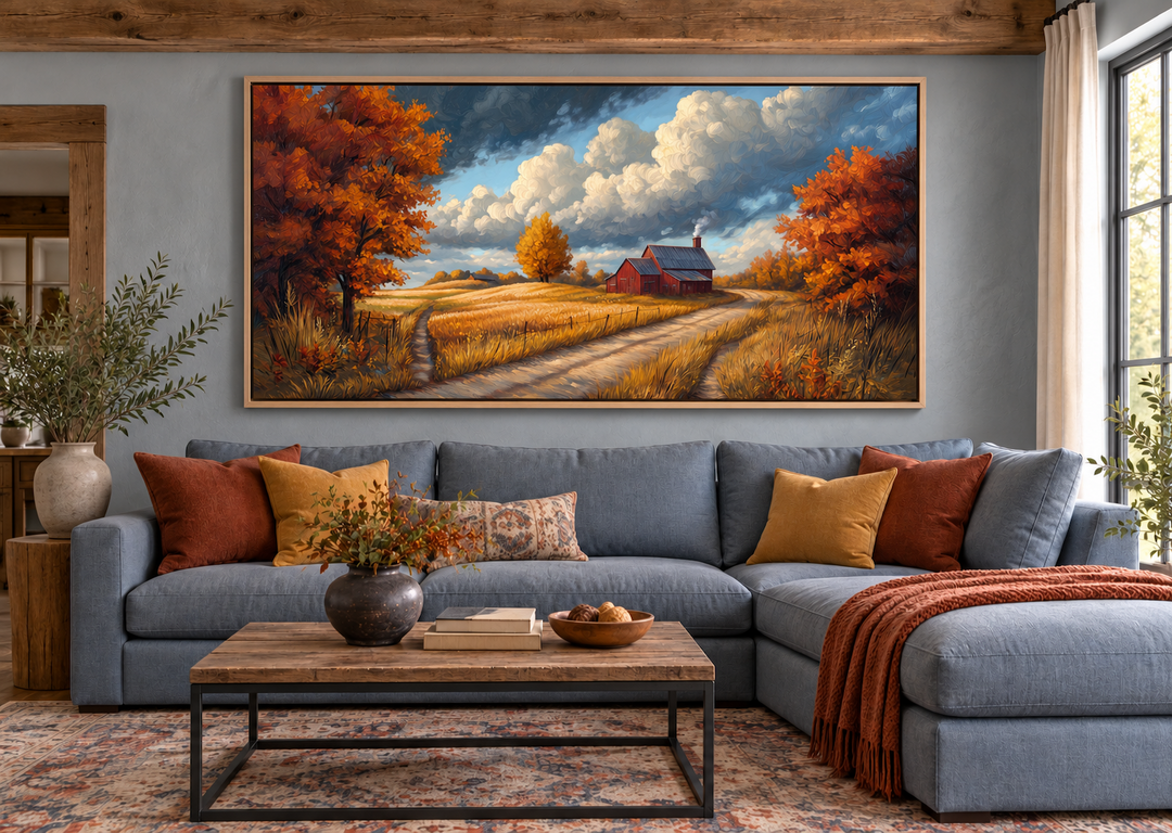 Rustic autumn barn landscape wall art above a blue sectional sofa in a cozy living room.