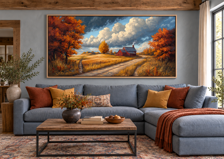 Rustic autumn barn landscape wall art above a blue sectional sofa in a cozy living room.