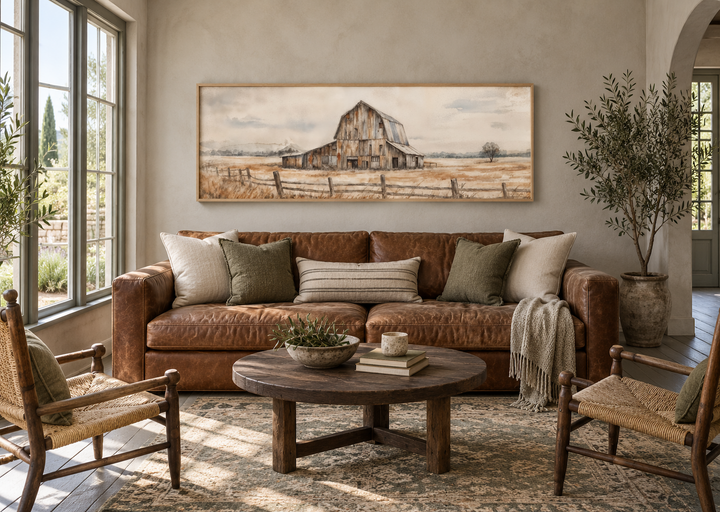 Rustic barn wall art in a long horizontal canvas print above a leather sofa in a farmhouse living room.