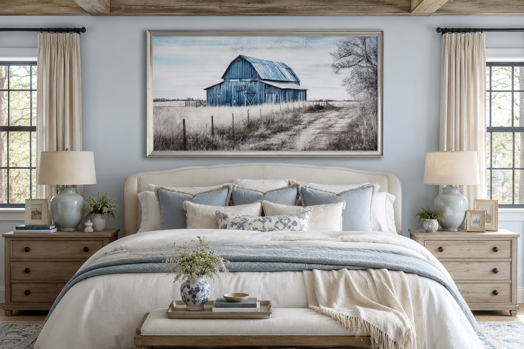 Rustic blue barn canvas painting framed above a bed in a farmhouse-style bedroom.