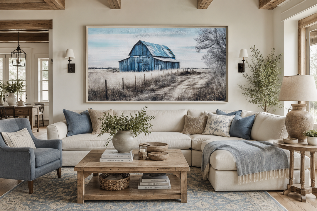 Large rustic blue barn canvas painting centered above a white sectional sofa in a farmhouse room.