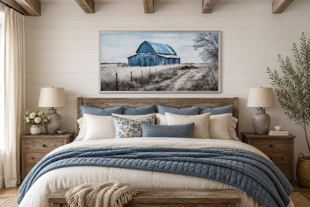 Rustic blue barn canvas painting hanging above a wooden bed in a farmhouse-style bedroom.