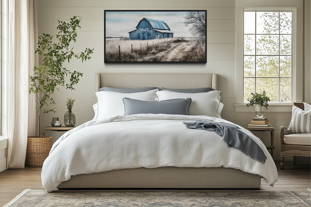 Rustic blue barn canvas painting hanging above a bed in a farmhouse-style bedroom.