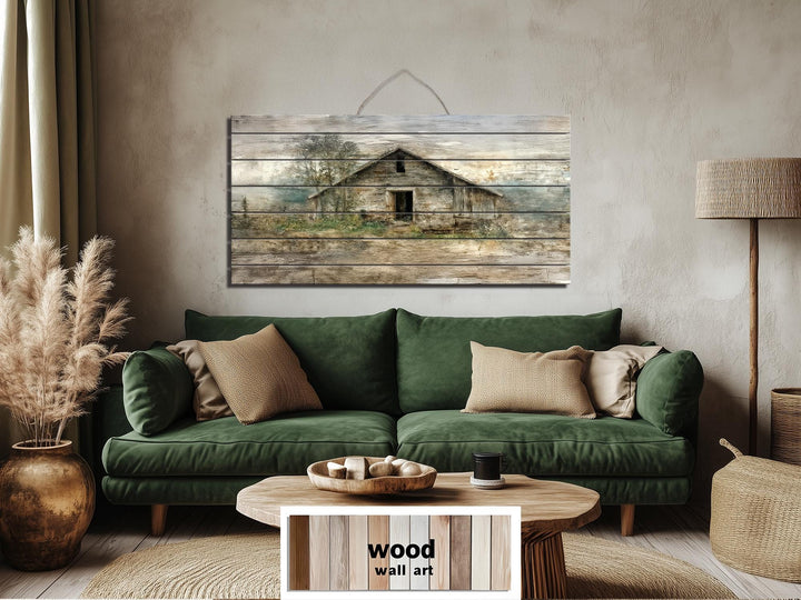 Rustic barn wall art printed on horizontal wood planks above a green sofa in a farmhouse living room.