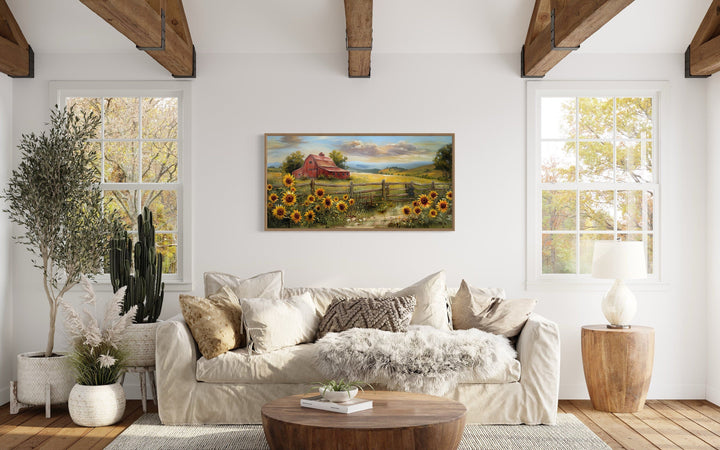 Rustic barn wall art featuring a red barn and sunflowers canvas print above a farmhouse sofa.