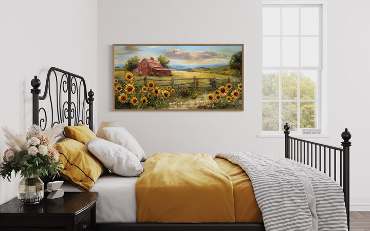 Rustic barn wall art canvas print featuring a red barn and sunflowers above a bed.