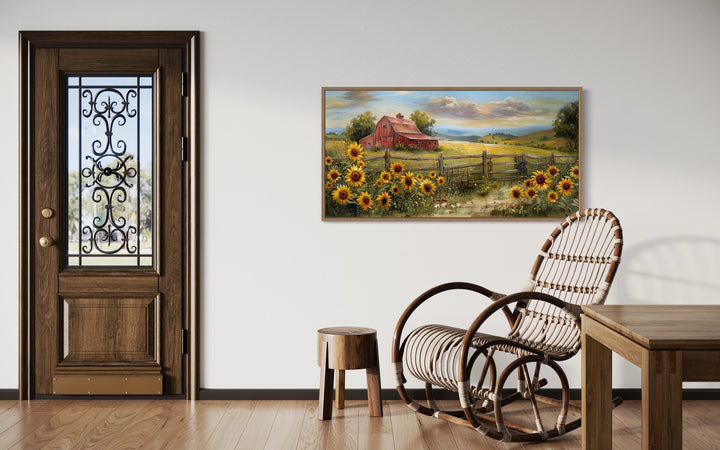 Panoramic rustic red barn and sunflower canvas print hanging on a white wall in a farmhouse room.