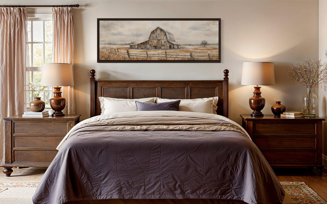 A long horizontal canvas print of a rustic barn in neutral tones hangs above a dark wood bed.