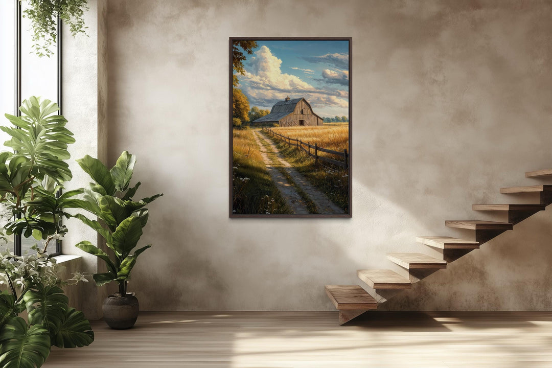 Vertical canvas print of a rustic barn in a golden field landscape hanging on a neutral wall.