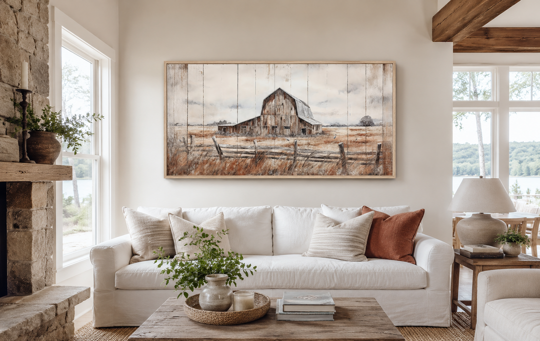 Rustic barn wall art on canvas in a farmhouse living room above a white sofa.