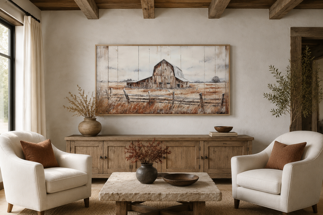 Rustic barn wall art featuring a weathered barn in a field, framed above a wooden sideboard.