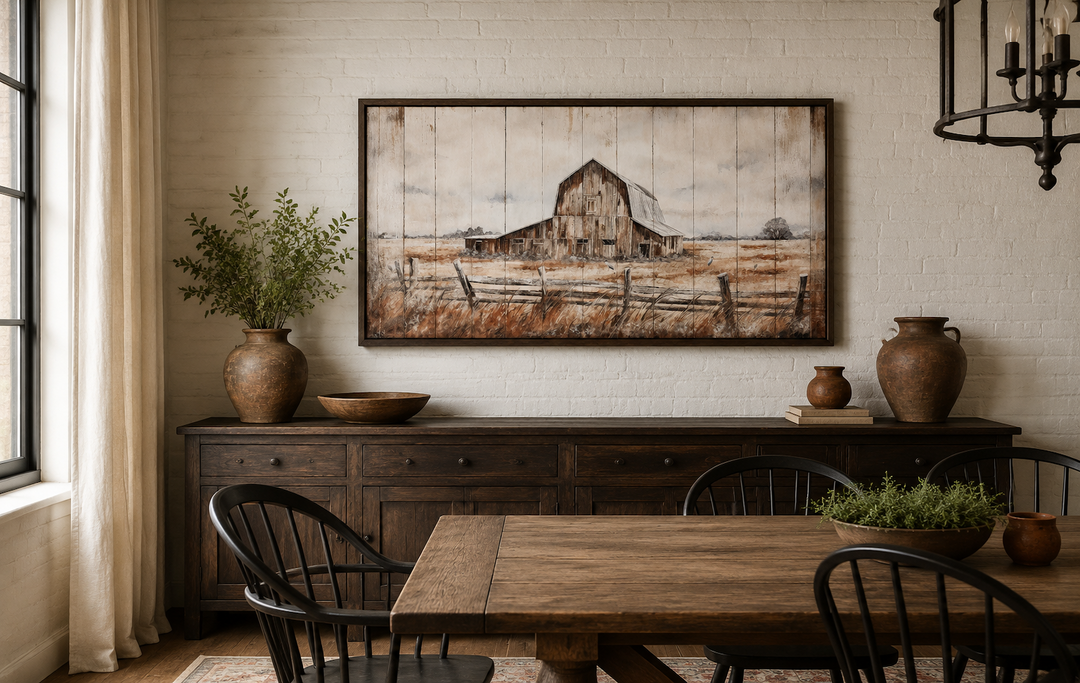 Rustic barn wall art in a dark wood frame hanging above a wooden sideboard in a farmhouse dining room