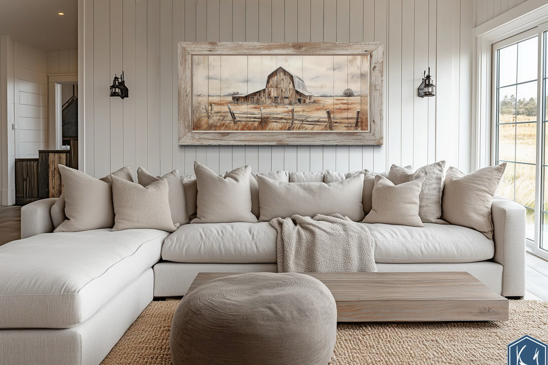 Rustic barn wall art in a weathered wood frame hanging above a neutral sectional sofa.