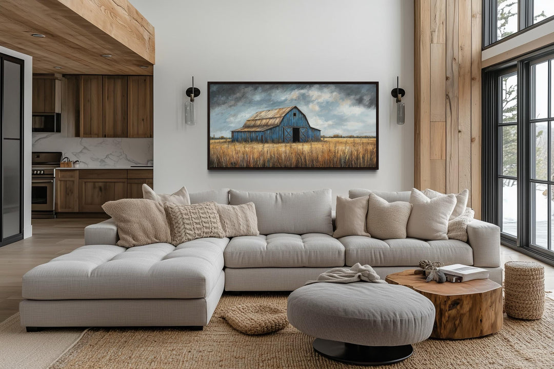 Rustic blue barn framed canvas wall art hanging above a modern sectional sofa in a farmhouse living.