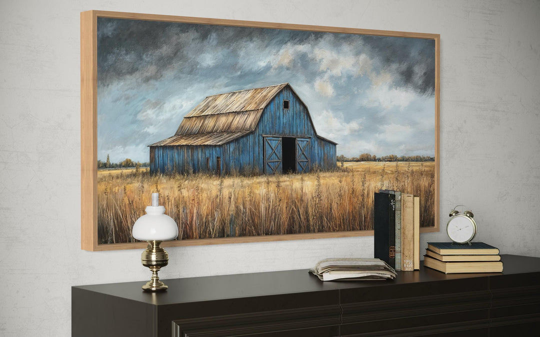 Rustic blue barn framed canvas wall art above a dark wood dresser with vintage decor.