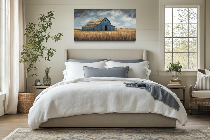 Rustic blue barn canvas wall art hanging above a bed in a farmhouse-style bedroom.