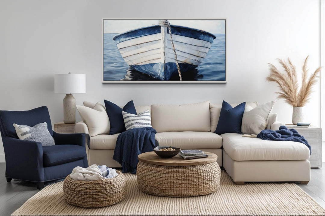 Rustic blue and white boat canvas wall art hanging above a neutral sofa in a coastal living room.