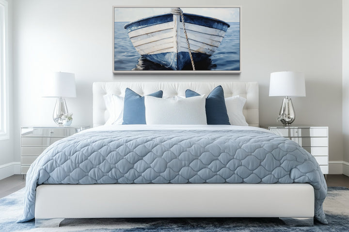 Rustic blue and white boat canvas wall art hanging above a bed in a coastal-themed bedroom.