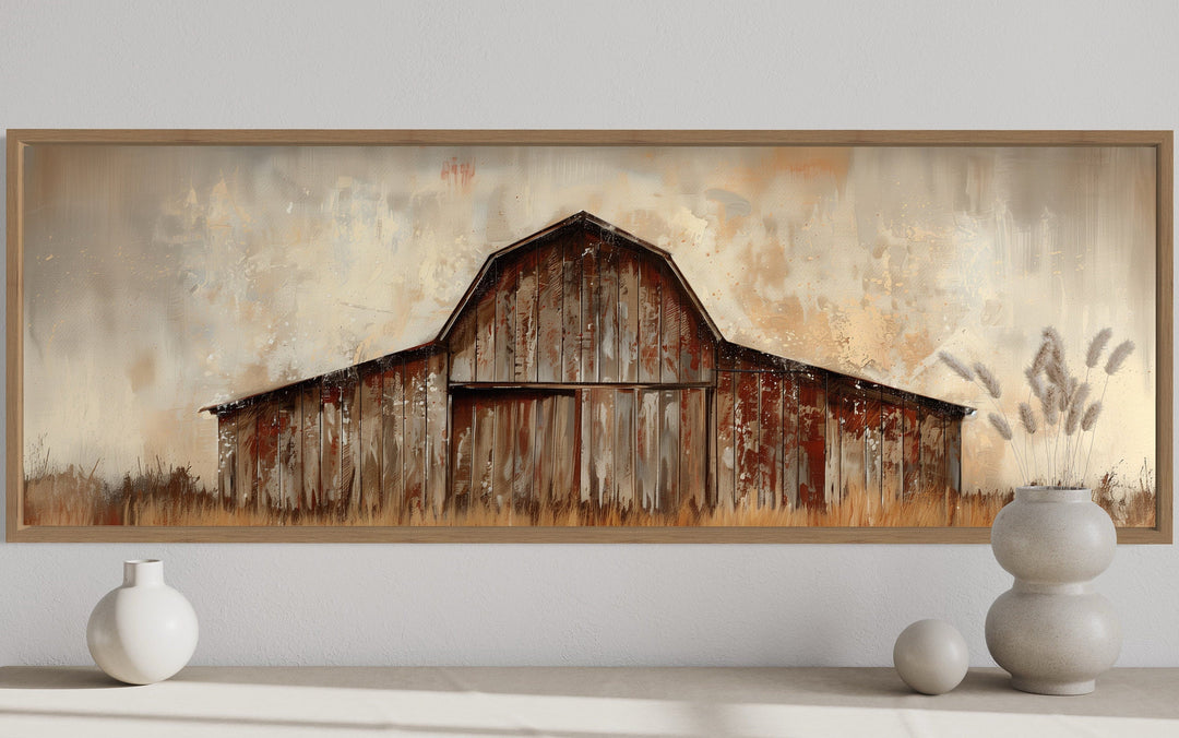 Panoramic framed canvas wall art of a rustic brown barn in a farmhouse style on a white wall.