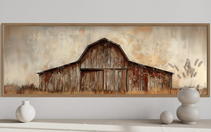 Panoramic framed canvas wall art of a rustic brown barn in a farmhouse style on a white wall.