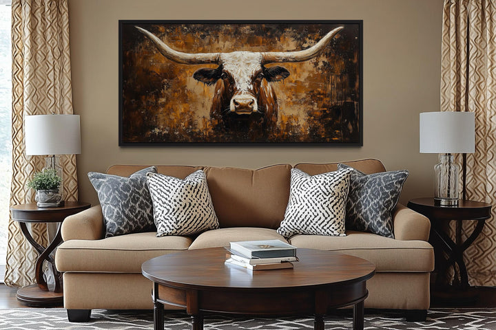 Rustic longhorn bull painting on an abstract western background canvas wall art above a sofa.