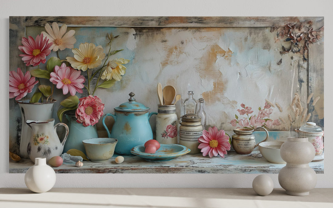 Rustic chic kitchenware framed canvas wall art with blue teapot, pink flowers, and pastel ceramics.