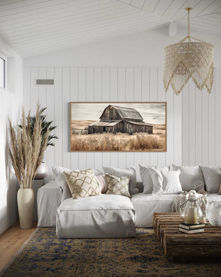 Rustic chic old farm barn painting on wood framed canvas wall art in a cozy white living room.