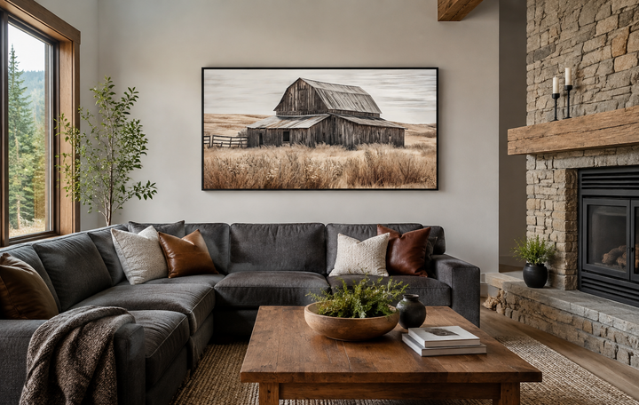 Rustic chic old farm barn painting on wood framed canvas wall art above a dark sectional sofa.