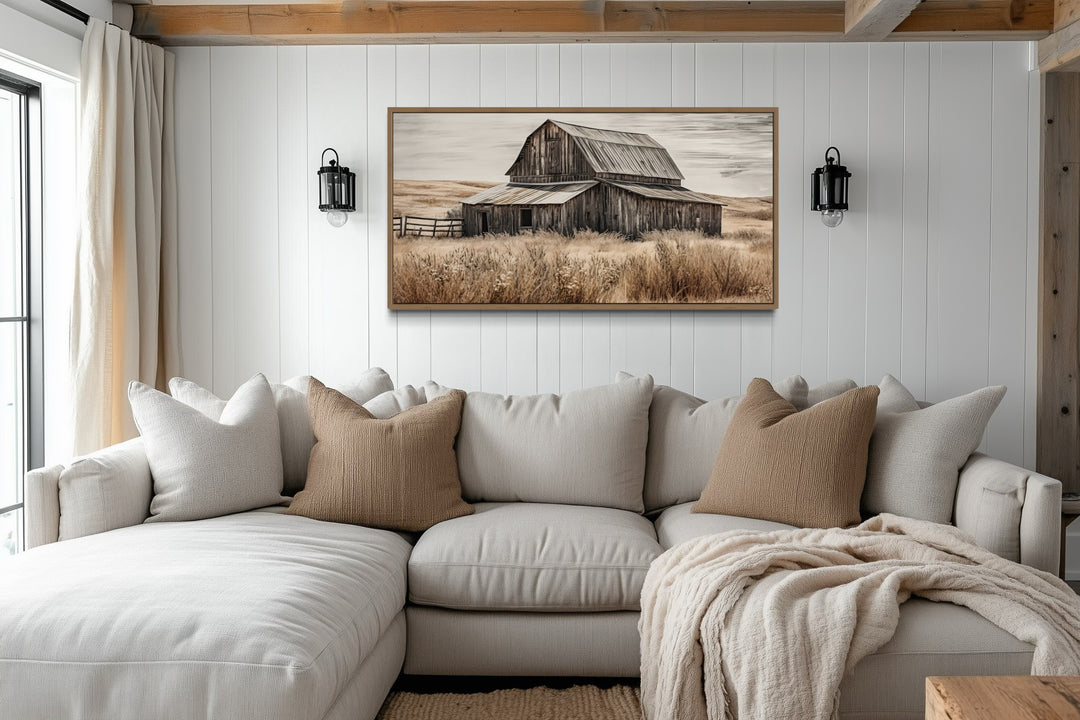 Rustic chic old farm barn painting on wood framed canvas wall art above a neutral sectional sofa.