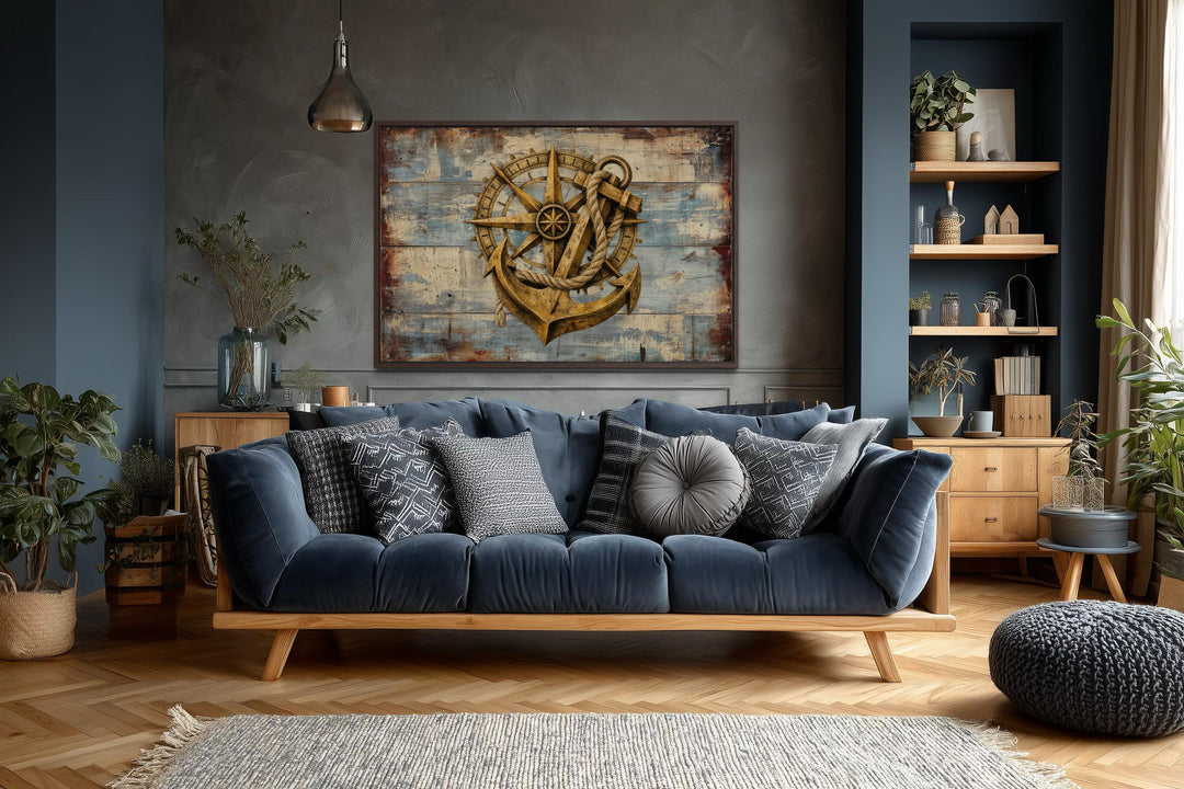 Rustic compass and anchor canvas wall art on weathered blue wood in a moody nautical living room.