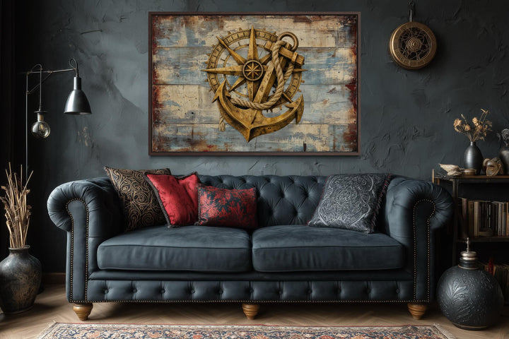 Rustic compass and anchor on blue wood canvas wall art in a dark, moody living room.