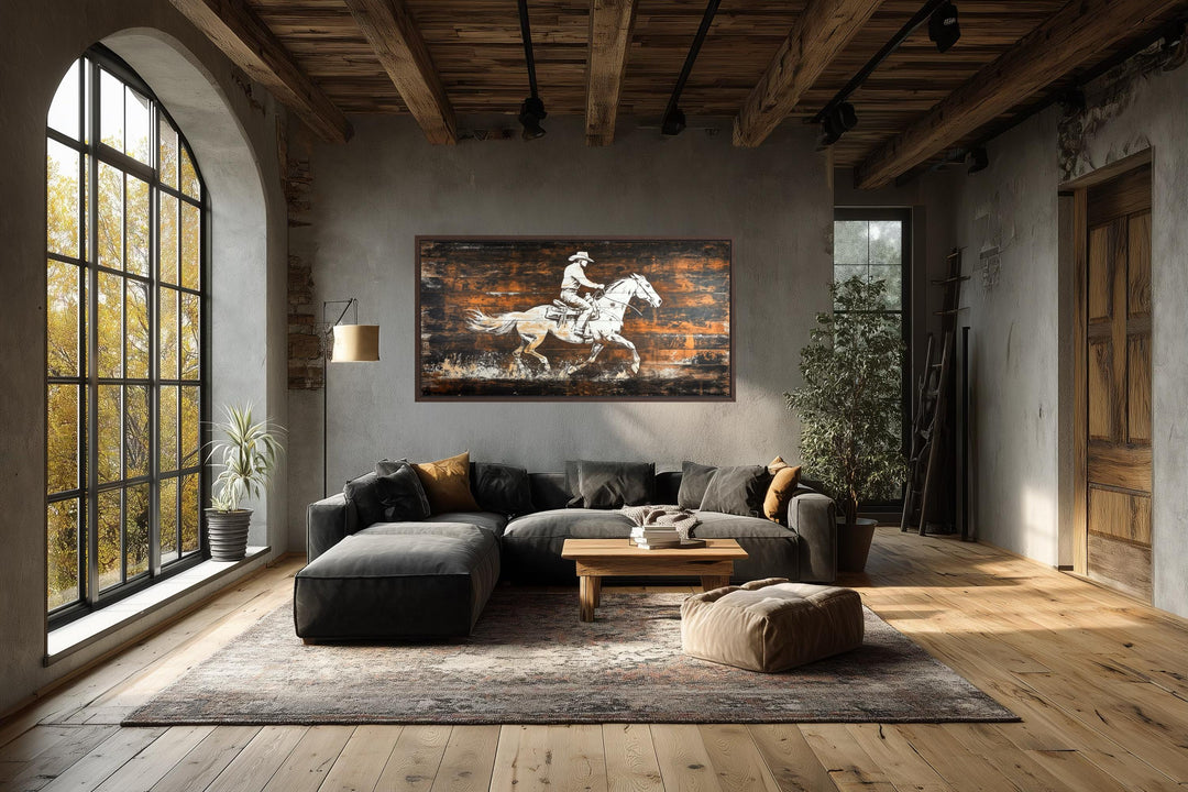 Rustic cowboy on horse canvas wall art on dark wood planks in a modern industrial living room.