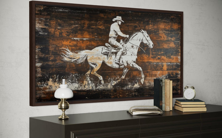 Rustic cowboy on horse canvas wall art with a wood plank background in a dark wood frame.