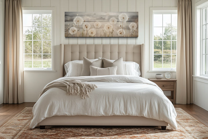 Rustic dandelion painting on wood, long horizontal wall art hanging above a bed in a bedroom.