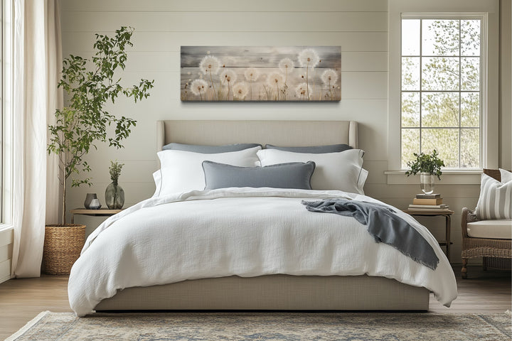 Rustic dandelions painting on wood long horizontal wall art hanging above a bed in a bedroom.