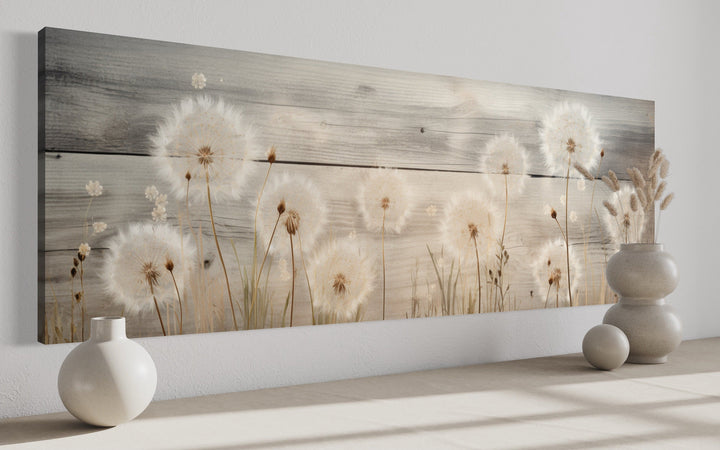 Rustic dandelion painting on wood, long horizontal framed canvas wall art above a shelf.