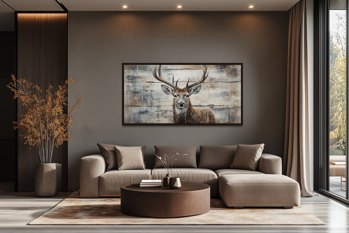 Rustic deer painting on wood canvas wall art above a modern sofa in a cabin-style living room.