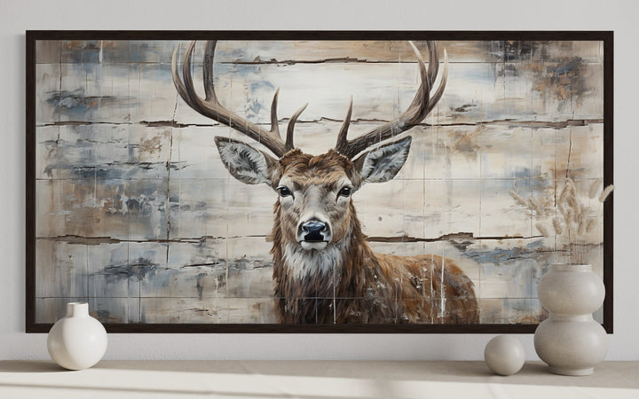 Rustic deer painting on wood-textured canvas with a dark frame, ideal for cabin wall decor.