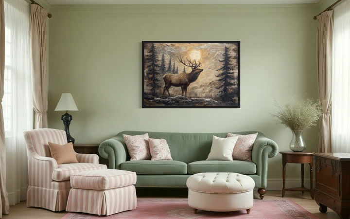 Rustic elk in winter forest painted on wood framed canvas wall art hanging above a green sofa.