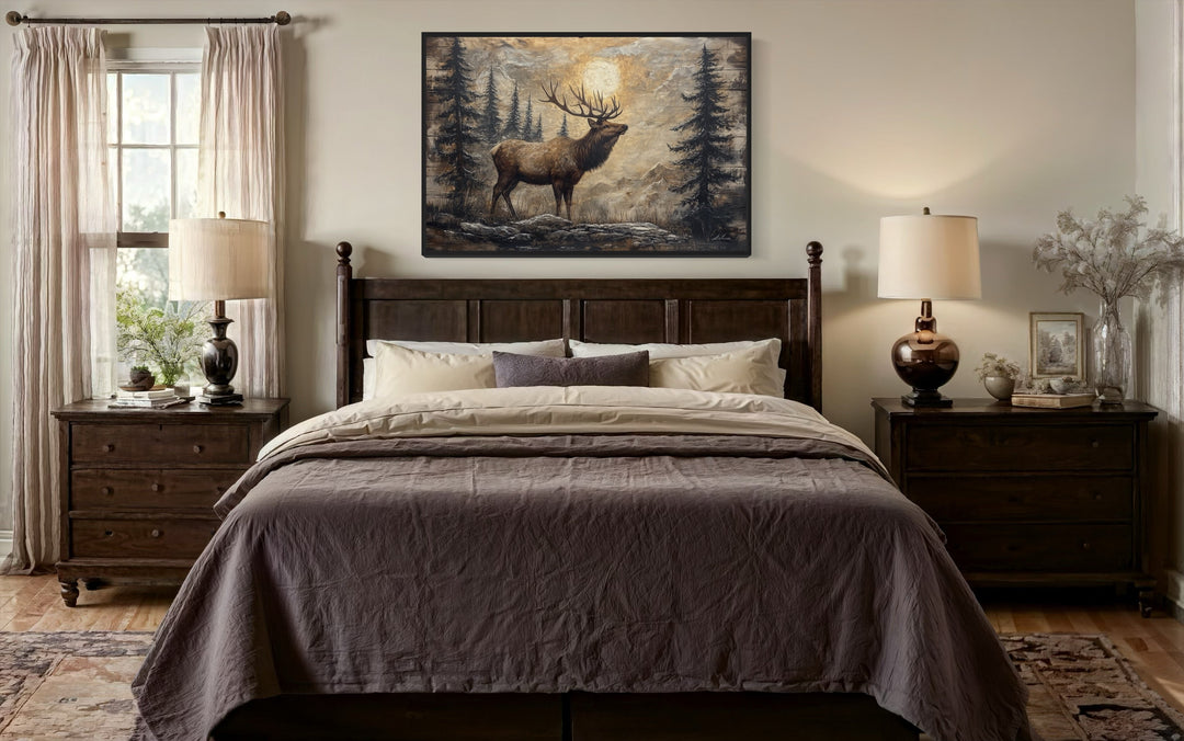 Rustic framed canvas wall art of an elk in a winter forest hanging above a dark wood bed.